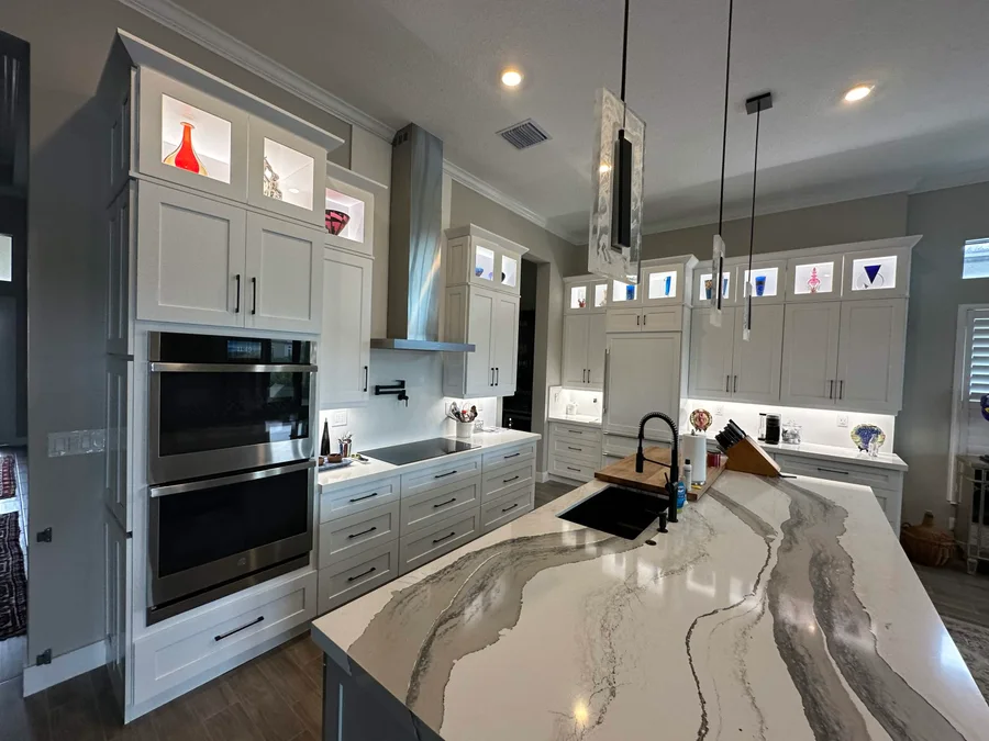 Expansive veined countertops and full-height kitchen cabinetry